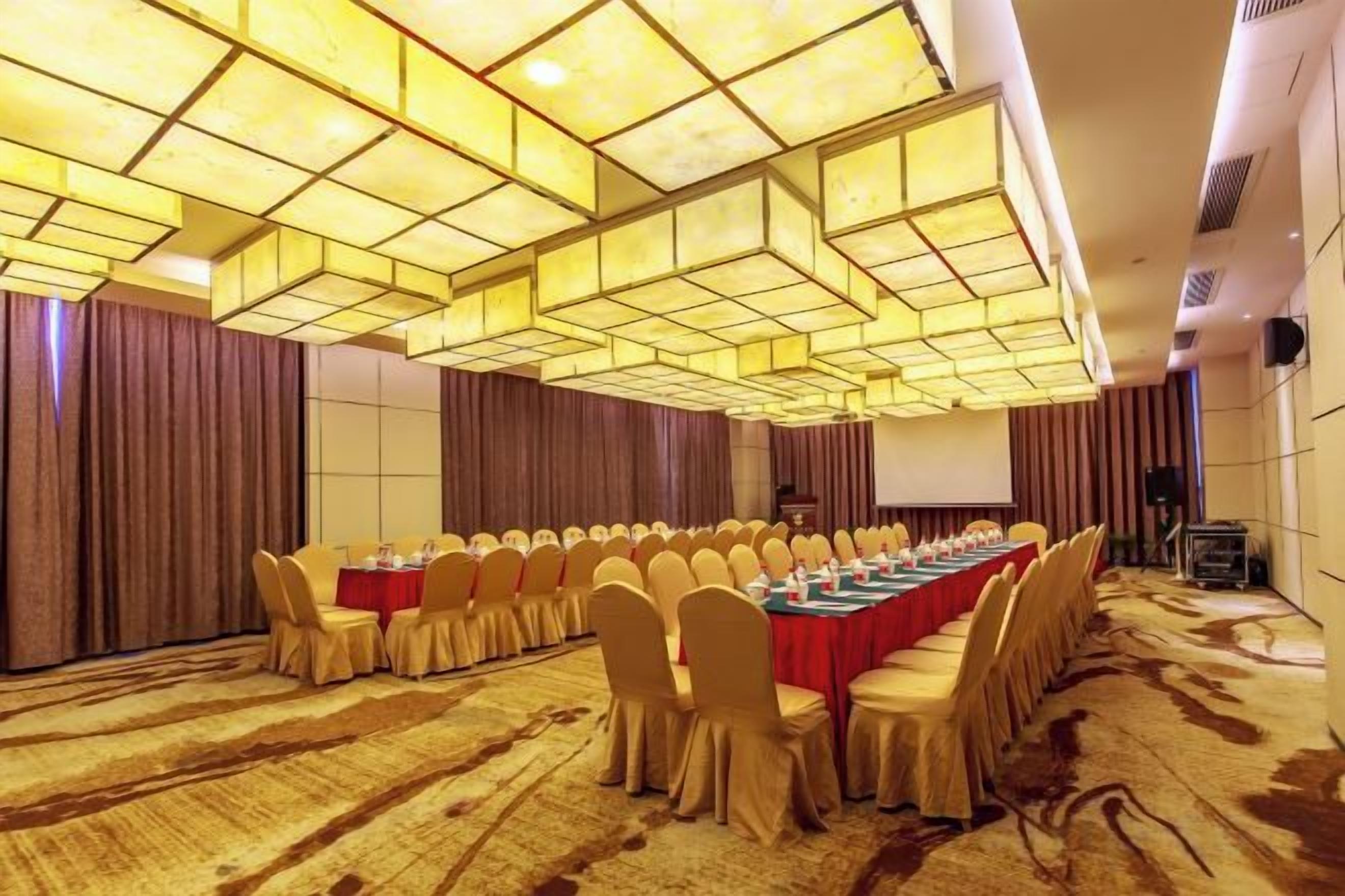 Un salón de conferencias con una larga mesa, sillas y piso alfombrado.