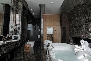 A modern bathroom with a marble countertop, a large bathtub, and a wooden panel wall. - Huaxin Hotel (XIANNING)