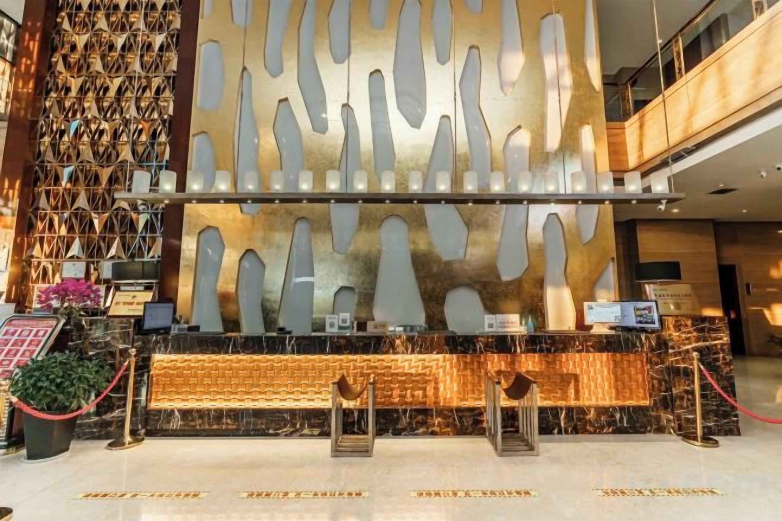 A reception area with a modern design, featuring a patterned wall and a reception desk.