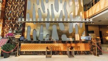 A reception area with a modern design, featuring a patterned wall and a reception desk.