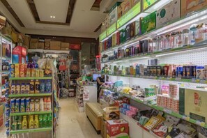 A grocery store aisle with shelves stocked with various products. - Huaxin Hotel (XIANNING)