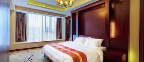 Una habitación de hotel con una cama grande, una araña, una ventana con cortinas y un cabecero de madera.