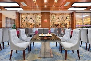 A conference room with a glass table, grey upholstered chairs, and a patterned wall. - Huaxin Hotel (XIANNING)