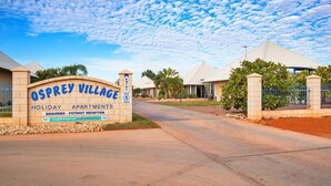 Osprey Village Holiday Apartments with a clear sky and a sign indicating a slow 5 km/h speed limit. - Osprey Holiday Village Unit 203/1 Bedroom - Villa with a Pool in the Complex (EXMOUTH)