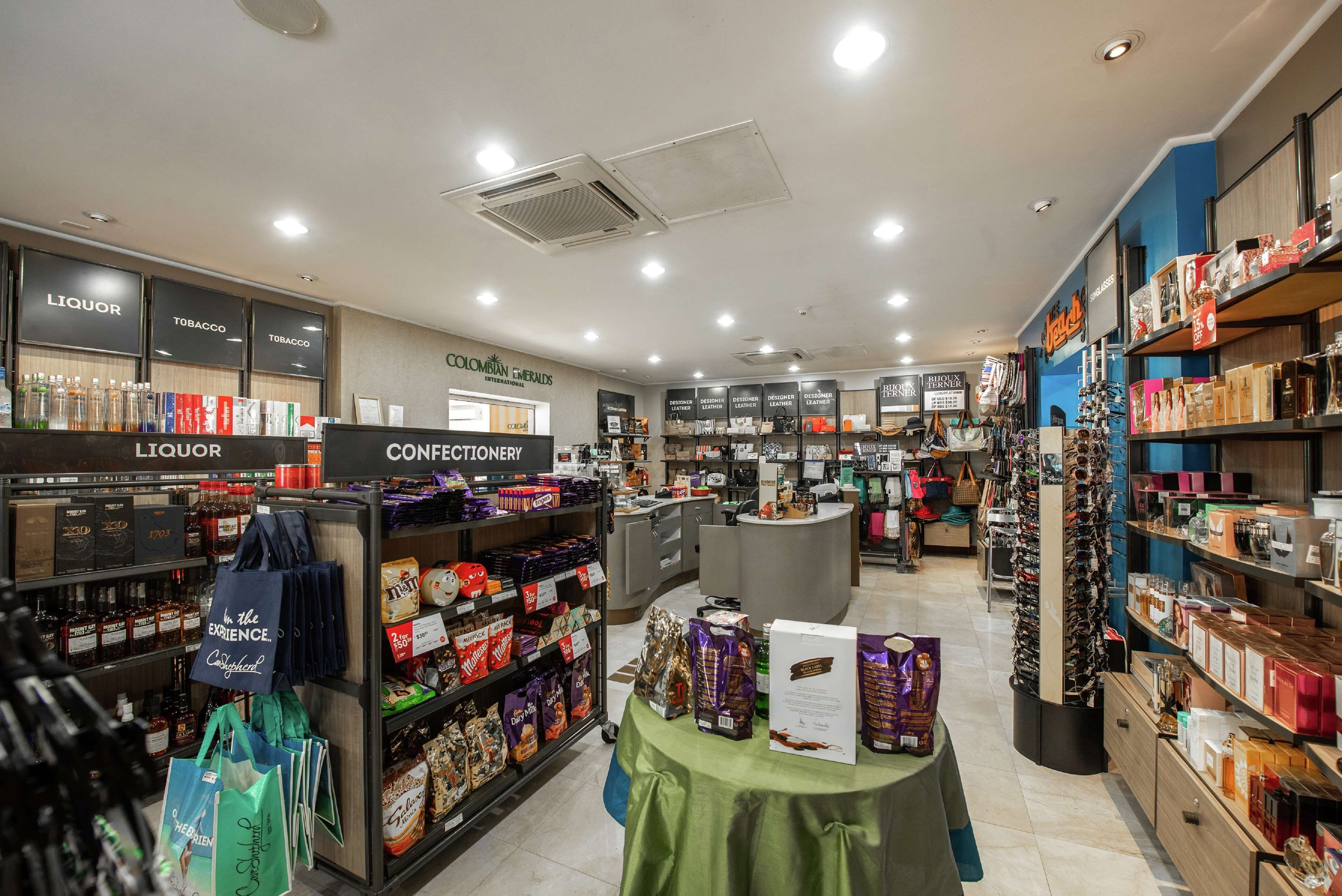 A store interior with sections labeled 'Liquor' and 'Confectionery', shelves stocked with various products, and a checkout counter.