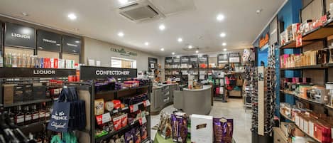 A store interior with sections labeled 'Liquor' and 'Confectionery', shelves stocked with various products, and a checkout counter.