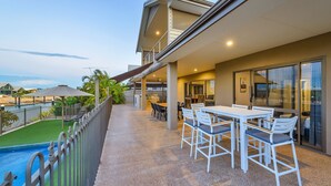 Ein Balkon mit Pool, Sitzgelegenheit im Freien und Meerblick.