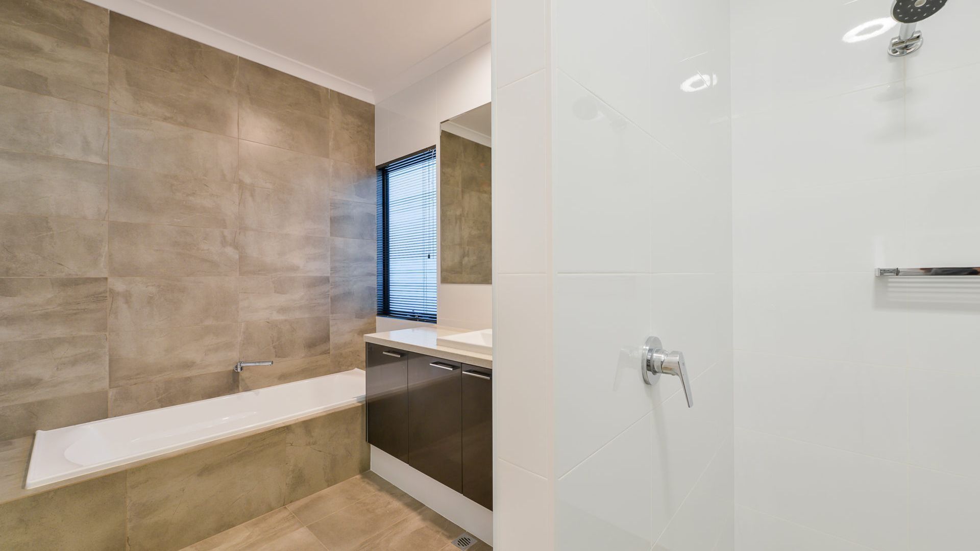 A modern bathroom with a bathtub, a shower, and a toilet.