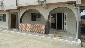 Un edificio moderno con zona de recepción, entradas arqueadas y fachada de baldosas.