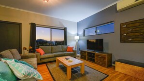 A modern living room with a sofa, coffee table, and TV.