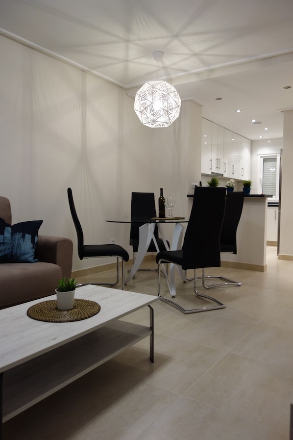 Un espace repas moderne comprenant une table, des chaises et un luminaire suspendu.
