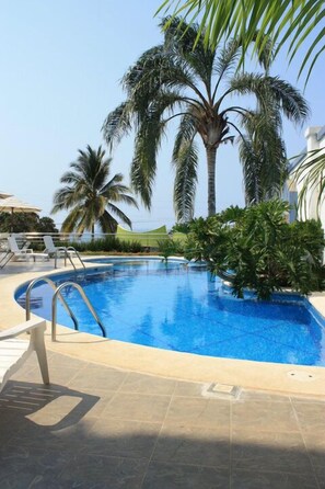 A swimming pool with palm trees, lounge chairs, and a tiled deck. - Dayz Hotel Caleta De Campos (Caleta de Campos)