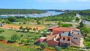 A coastal town with a marina, green fields, and houses with red roofs. - Adriana by Interhome (Pula)