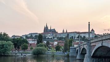 Eine historische Brücke über einem Fluss, im Hintergrund eine Stadtansicht mit einem markanten Dom.