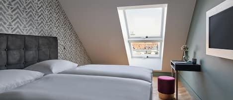 Un dormitorio con cama, ventana y televisor de pared.