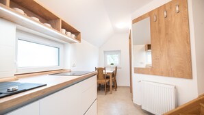 Eine moderne Küche mit weißen Schränken, einer Holz Arbeitsplatte und einem großen Fenster.