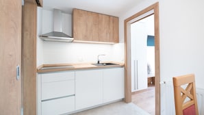 Eine moderne Küche mit weißen Schränken, einer Holz Arbeitsplatte und einer Edelstahl-Dunstabzugshaube.