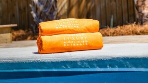 Un espace aménagé au bord de la piscine, avec deux serviettes pliées et posées sur le bord.