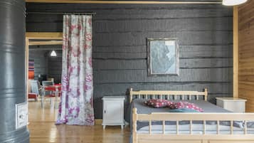 Une chambre à coucher avec un lit en bois, une table de chevet, une commode et une grande fenêtre avec des rideaux.