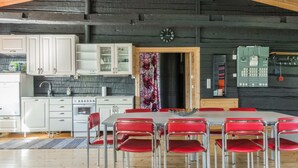 Een moderne keuken met witte kasten, een zwarte spatwand en een houten plafond.
