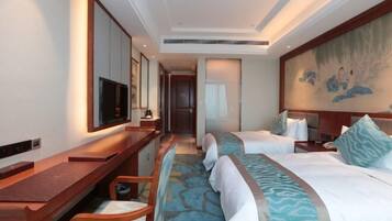 A hotel room with a bed, a desk, a chair, a television, and a painting on the wall.