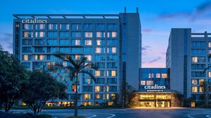 A modern hotel with a prominent entrance, multiple floors, and a well-lit facade.