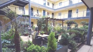 Un atrio de varios niveles con diversas plantas de interior y zonas de estar.