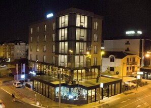 A multi-story hotel with a glass facade, a ground-level commercial area, and a visible entrance. - Union Hotel Podgorica (Podgorica)