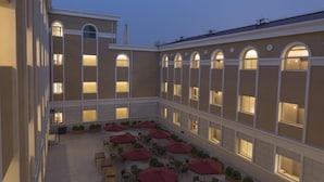 A courtyard with outdoor seating, large windows, and a building facade.