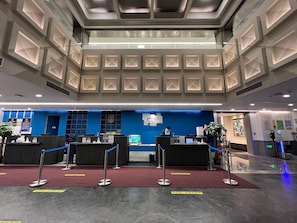 A hotel reception area with a modern design, featuring a blue accent wall, a reception desk, and a digital information board. - Holiday Inn Express Beijing Badaling (Yanqing)