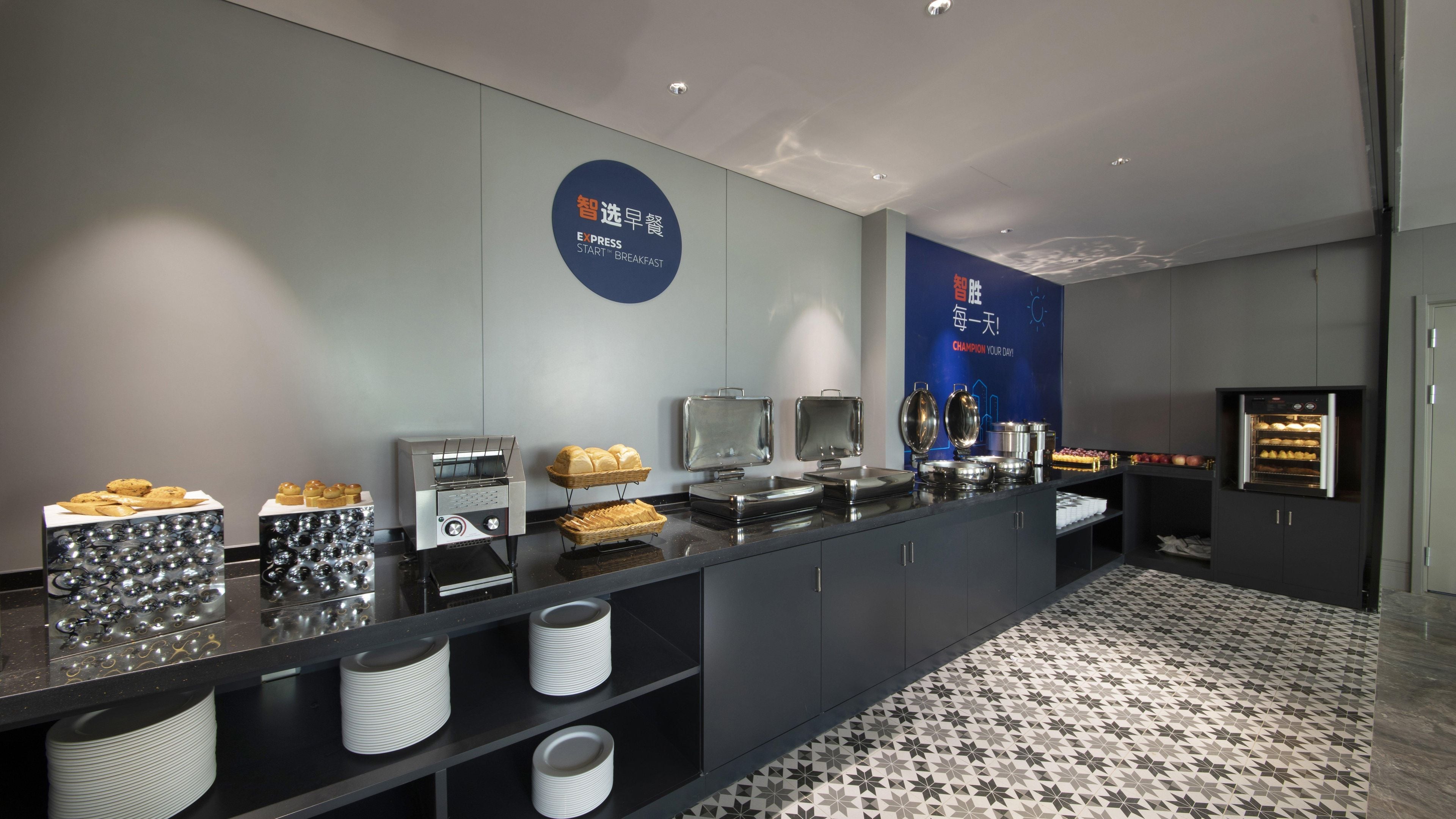 Ein Frühstücksbuffet mit verschiedenen Speisen, einer Kaffeemaschine und einem Kühlschrank.