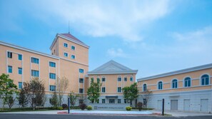 A multi-story hotel with a central tower, a symmetrical facade, and a landscaped courtyard. - Holiday Inn Express Beijing Badaling (Yanqing)
