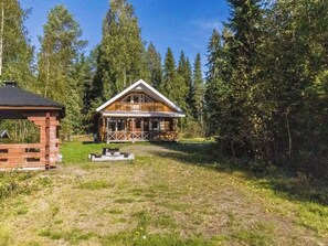 A cabin with a porch and a deck, surrounded by a forest. - Rinnepelto by Interhome (Nilsiä)