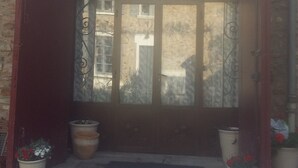 A rustic building entrance with a large wooden door and metal decorative elements. - The charm of wood ... (Écharcon)