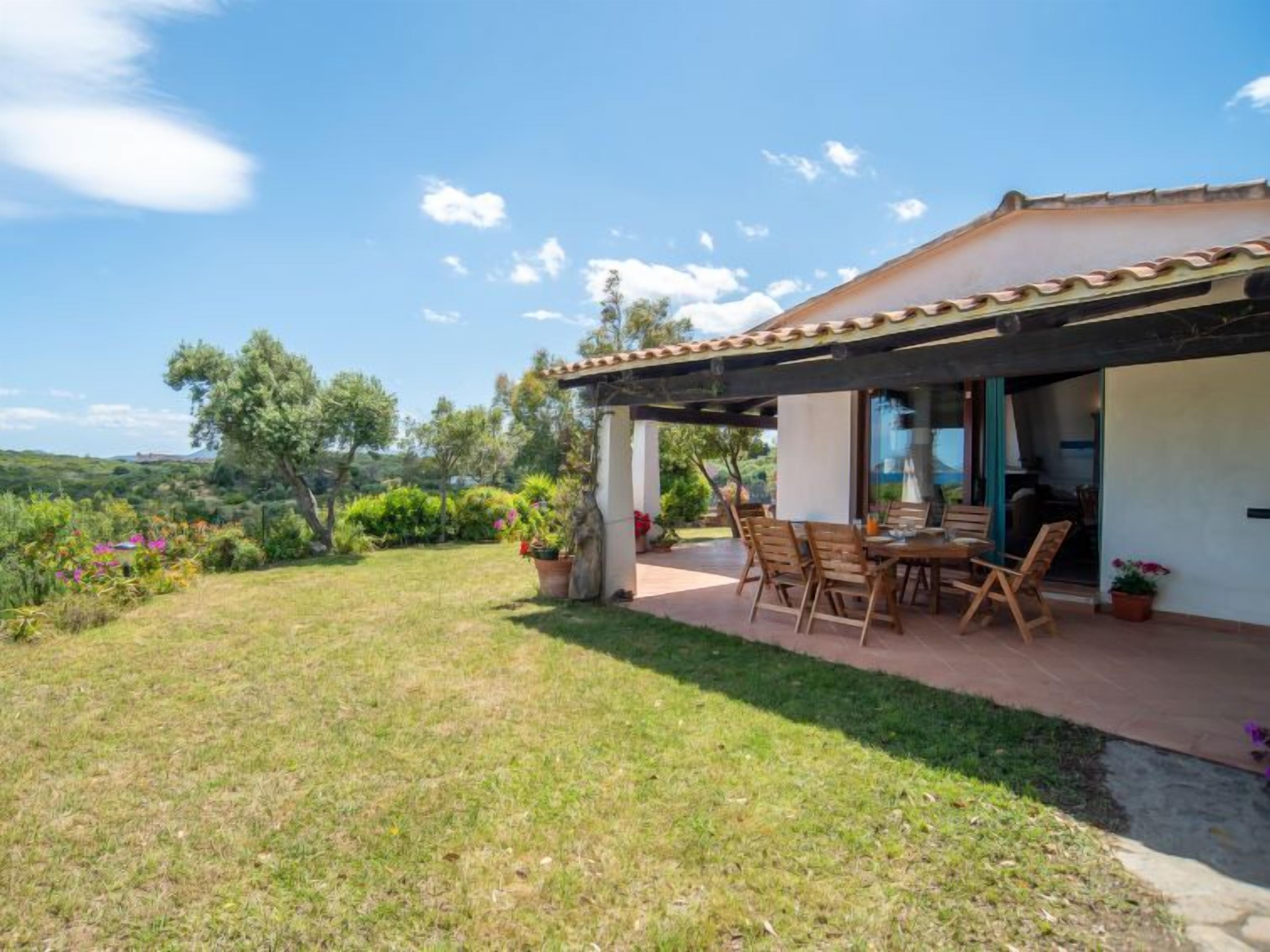 A patio with outdoor furniture, a covered area, and a view of the surrounding landscape.