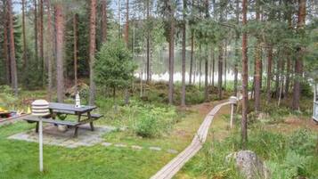 A forested area with a picnic table and a wooden walkway.