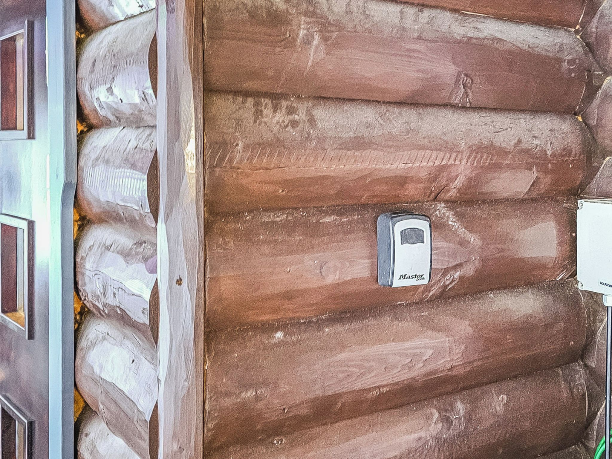 A log cabin with a door and a Master Lock on the door.