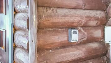 A log cabin with a door and a Master Lock on the door.