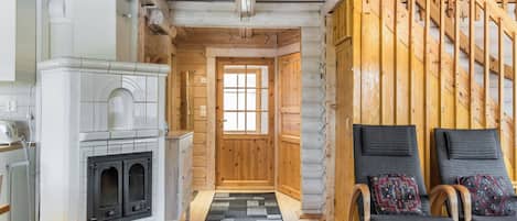 Un intérieur chaleureux avec une cheminée, des murs en bois et un escalier.