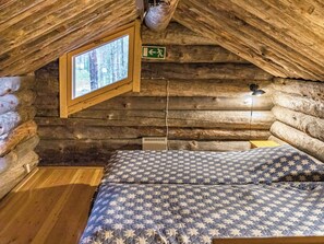 A log cabin room with a bed, a window, and an emergency exit sign. - Ylläsnäkyy 7 / karkelo by Interhome (Äkäslompolo)