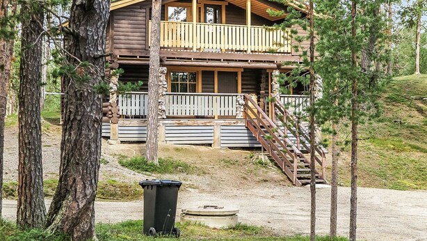 A two-story log cabin with a balcony and a staircase leading to the upper level. - Vacation home Ruska by Interhome (Raattama)