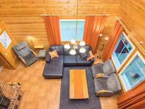A cozy cabin interior with a sofa set, two armchairs, a wooden coffee table, and a fireplace. - Lauttavalkama by Interhome (Hämeenlinna)