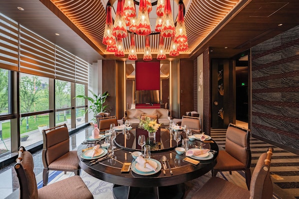 A modern dining area with a round table set for six, surrounded by comfortable chairs.