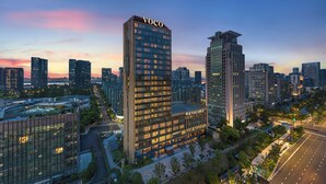 A high-rise building with the name "VOCO" prominently displayed at the top. - voco Hangzhou Binjiang Minghao by IHG (Hangzhou)