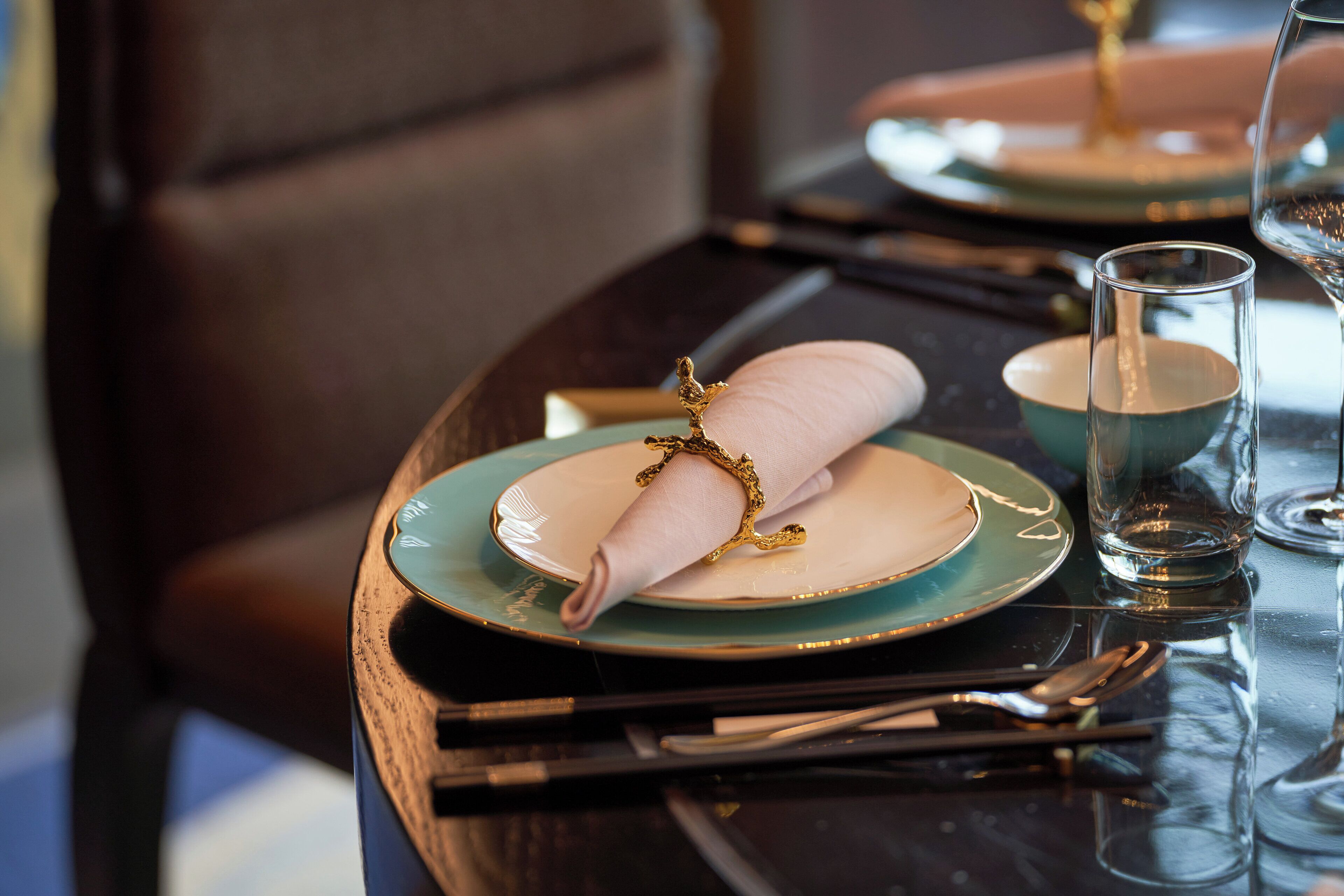 Une table à manger avec une serviette pliée, un verre et des couverts.