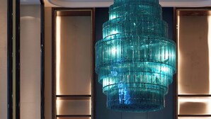 A lobby with a blue glass chandelier, shelves with books, a wooden bench, and a tiled floor. - voco Hangzhou Binjiang Minghao by IHG (Hangzhou)