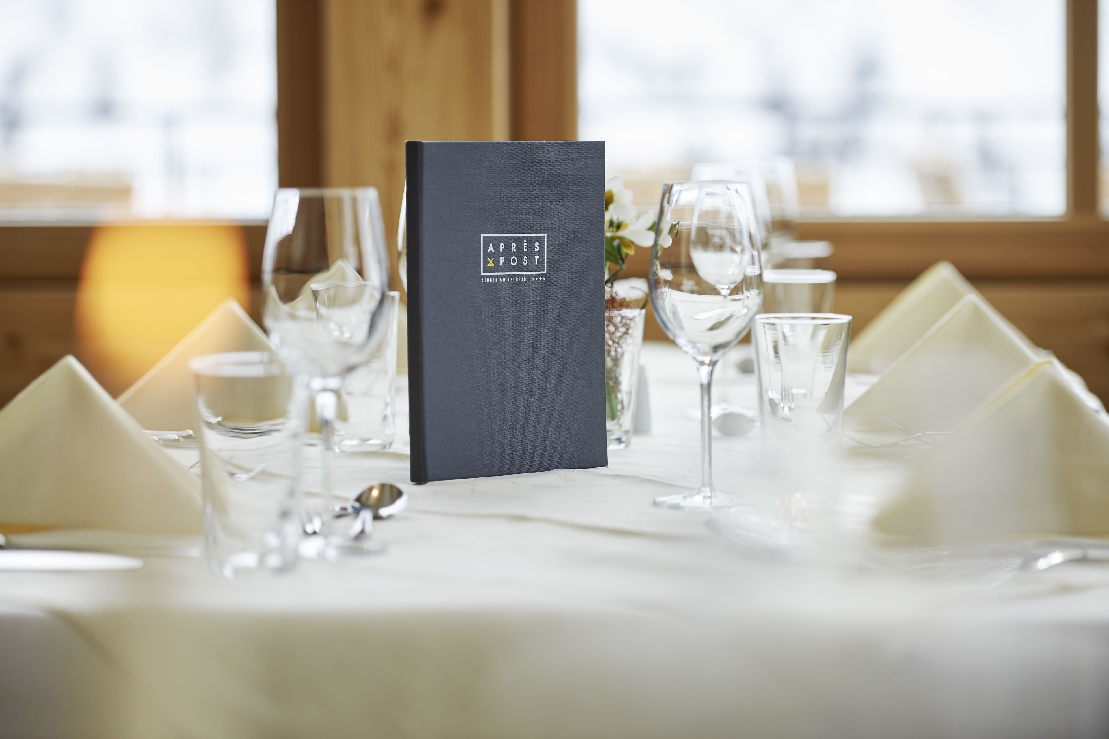 A table set with clear glassware, a menu, and white napkins.