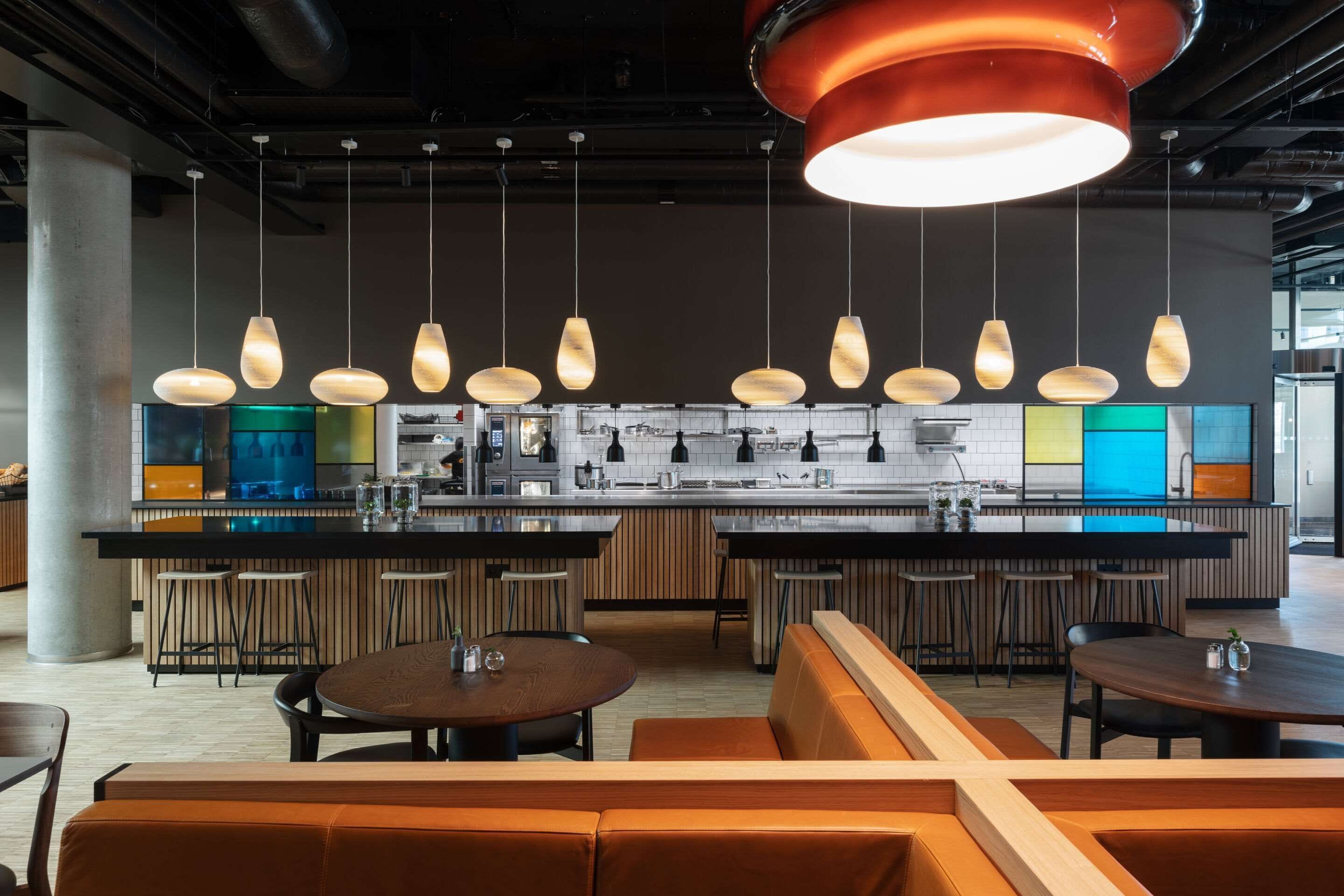 A modern kitchen with a central island, bar stools, and pendant lighting.