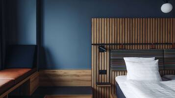 A modern bedroom with a wooden headboard, a bench, and a bed with white bedding.