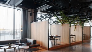 A modern interior with a sofa, chairs, a small table, and a dining area with a table and chairs.